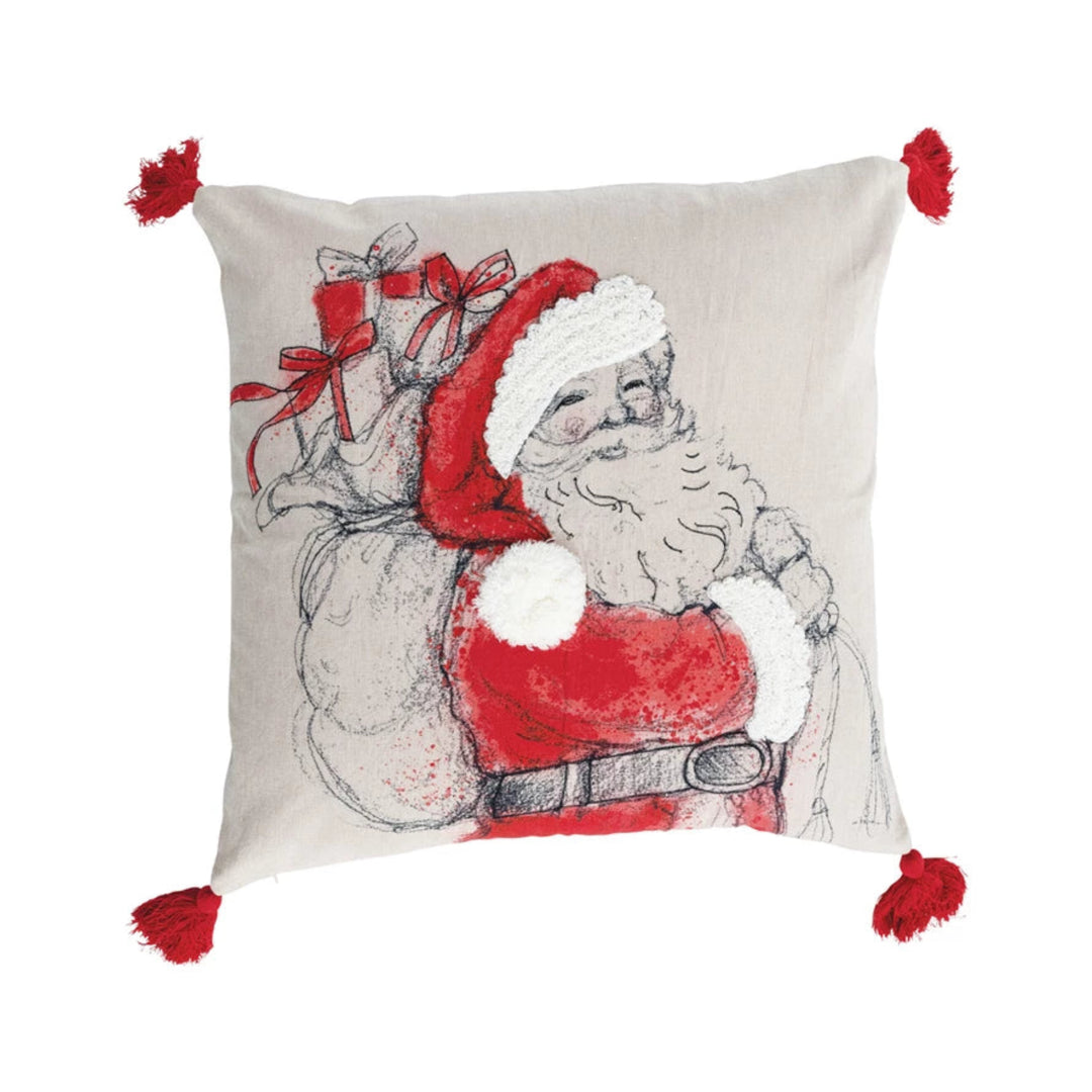 Decorative pillow with a Christmas design of a cat in a Santa hat and red coat on a beige background.