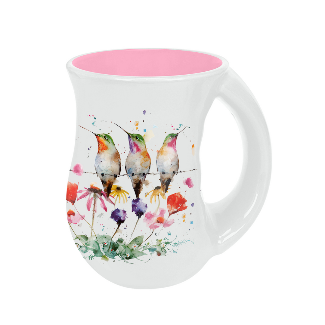 White mug with colorful hummingbird design and pink interior on a white background