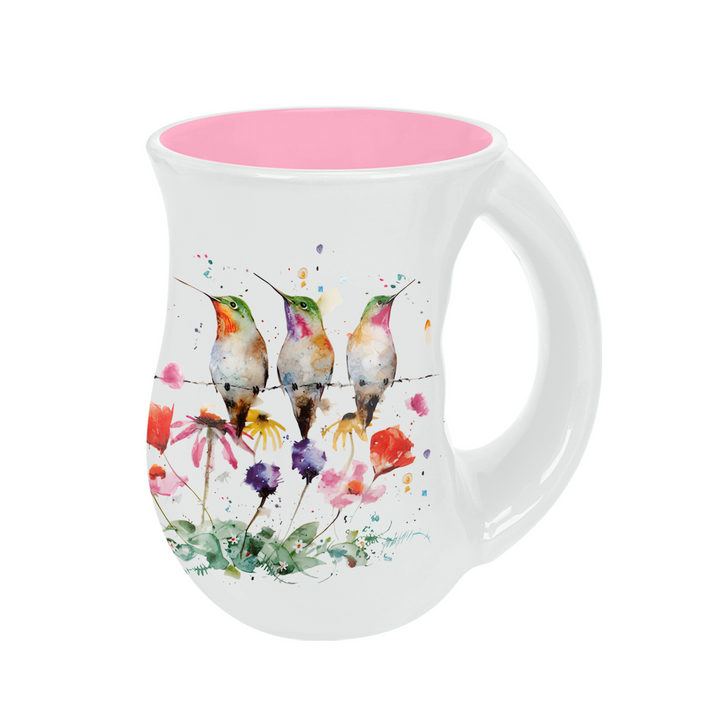 White mug with colorful hummingbird design and pink interior on a white background