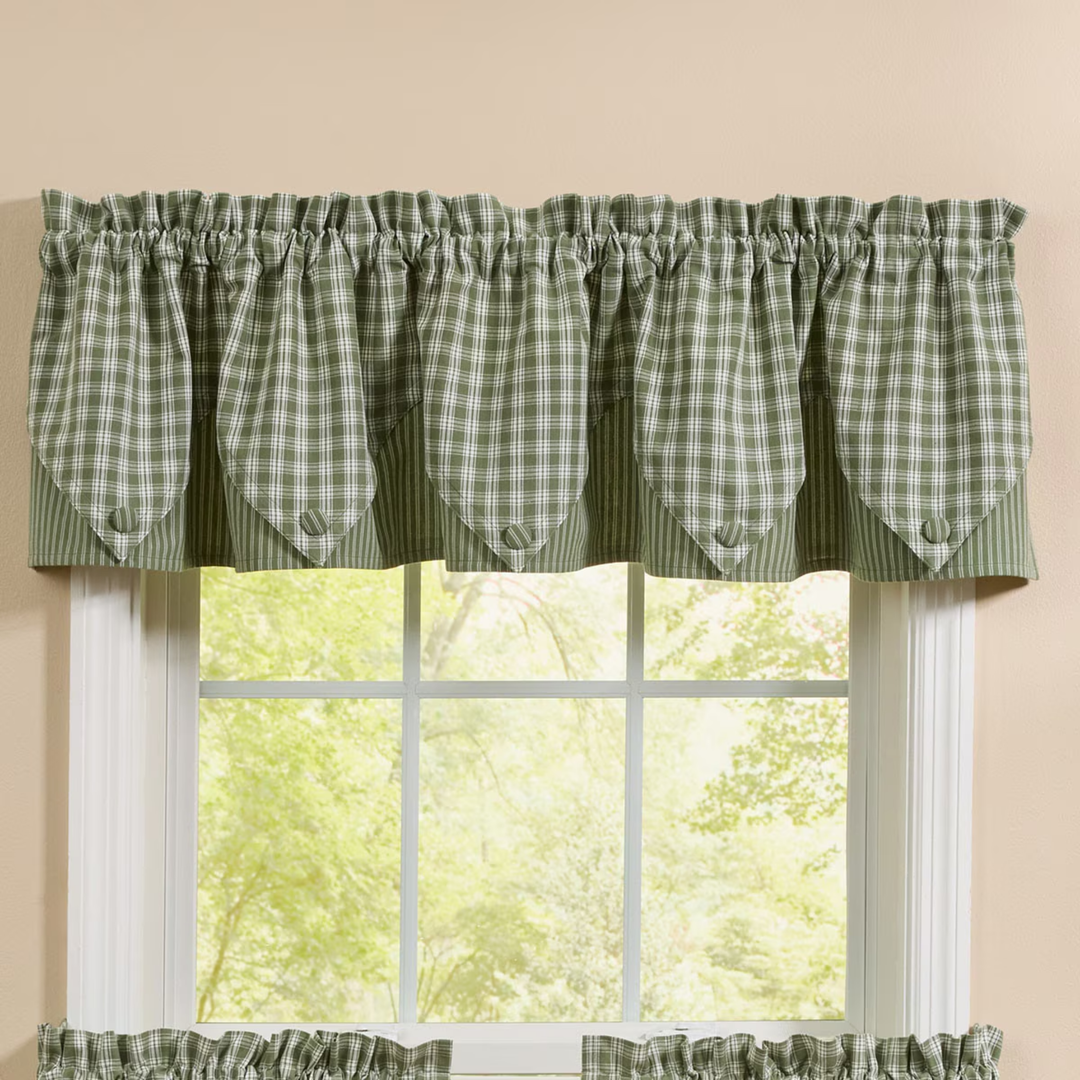 Green checkered curtain valance on a window with a beige wall background