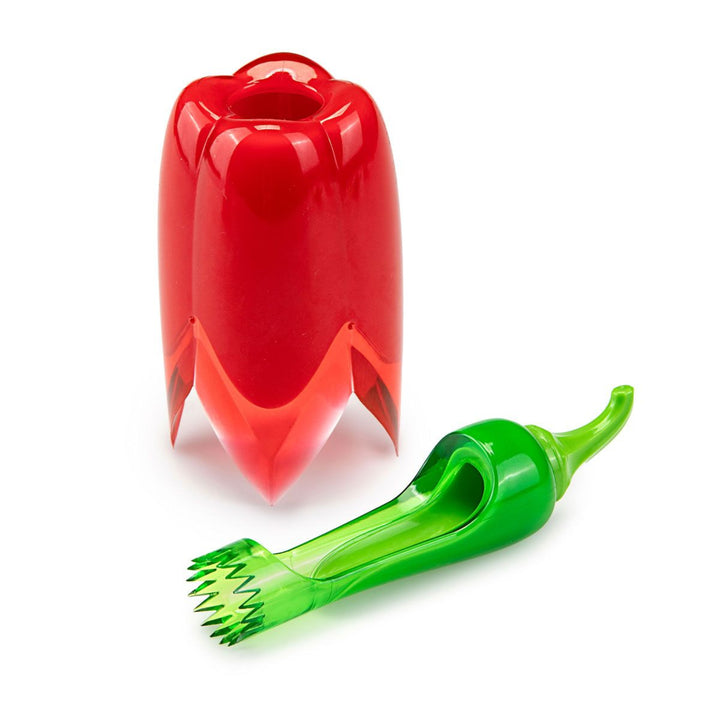 A red bell pepper-shaped container standing upright next to a green pepper-shaped utensil with a serrated tip, both on a clean white background.