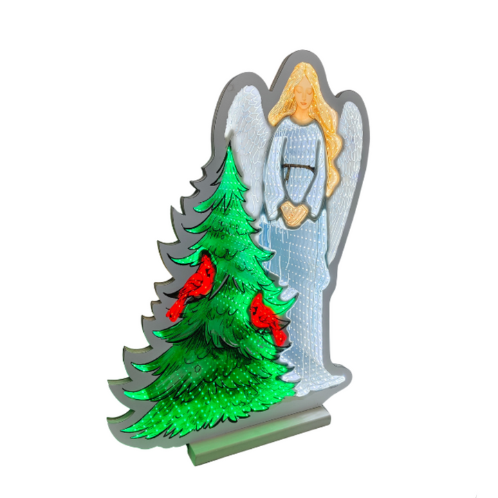 A decorative Christmas angel and tree standee with a silver glitter outline, a green Christmas tree with red ornaments, and a white angel figure with gold hair, shown on a plain white background.