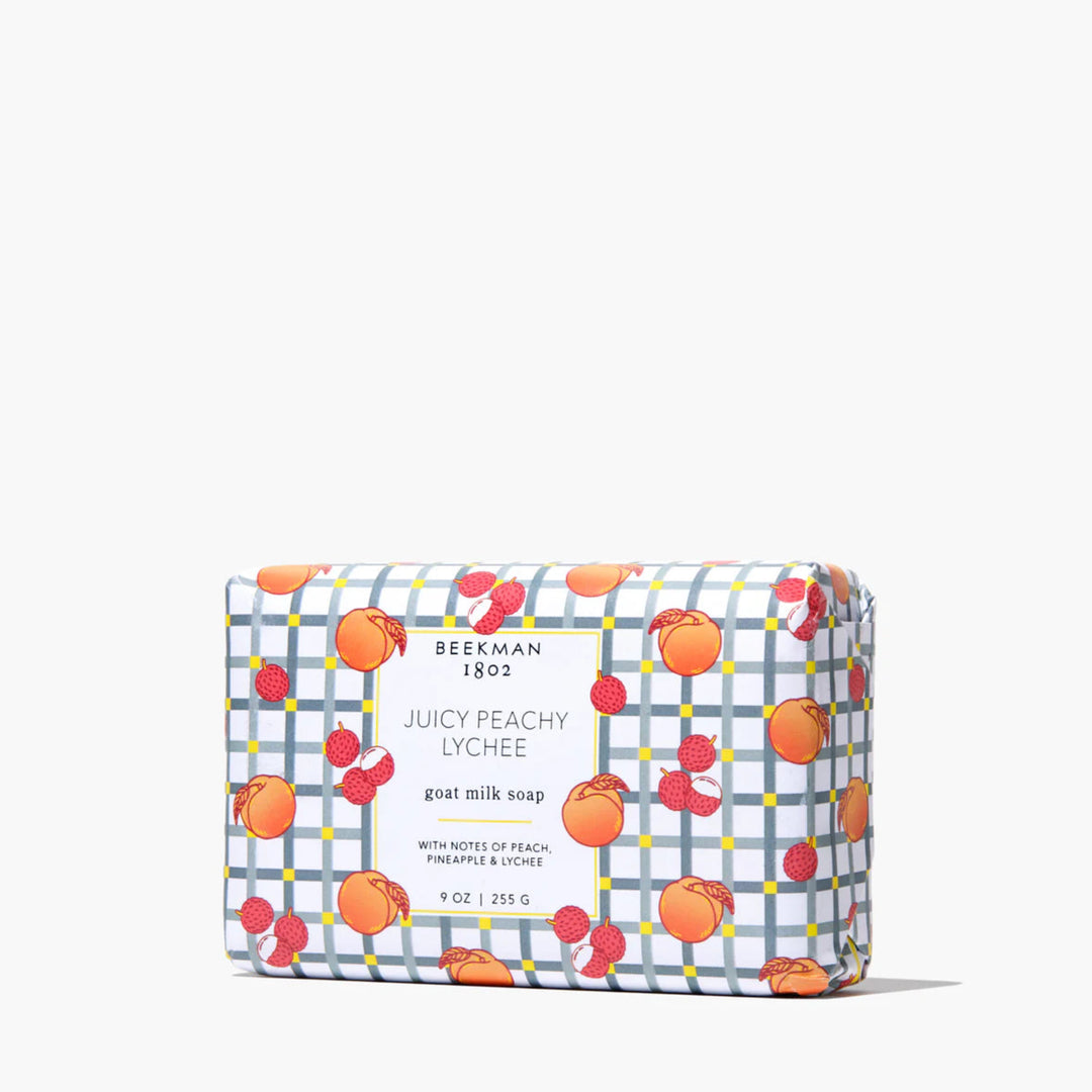 Soap bar with colorful packaging featuring peaches and lychees on a white background
