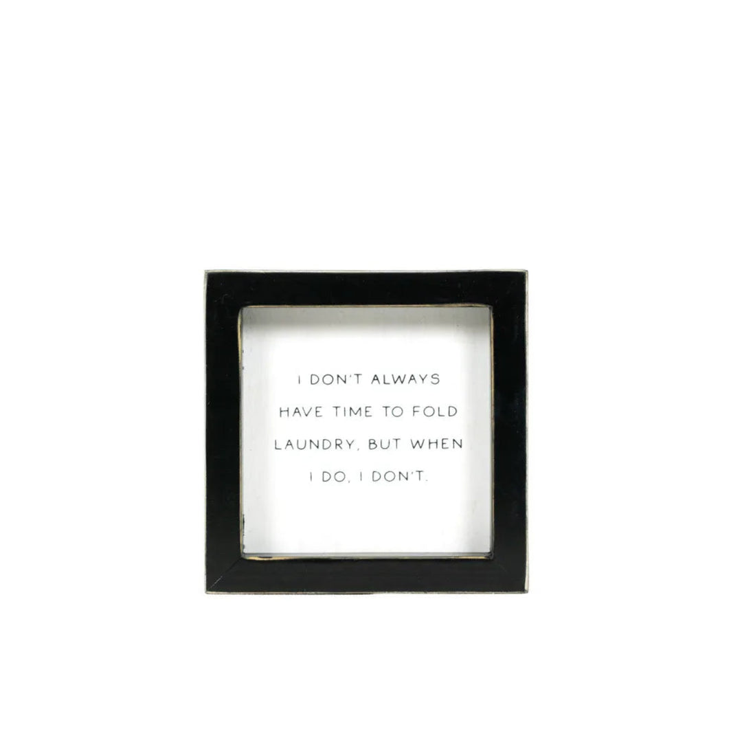 Black-framed wall art with humorous text on a white background