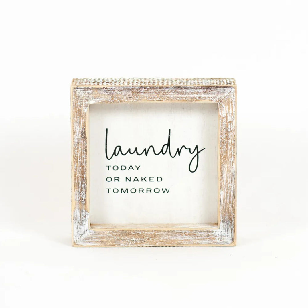 Wooden-framed sign with humorous laundry-themed text on a white background