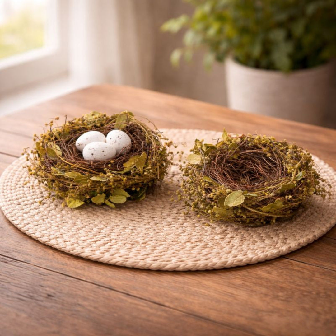Leafy Twig Nest on a woven placemat on a wooden table with a houseplant in the background