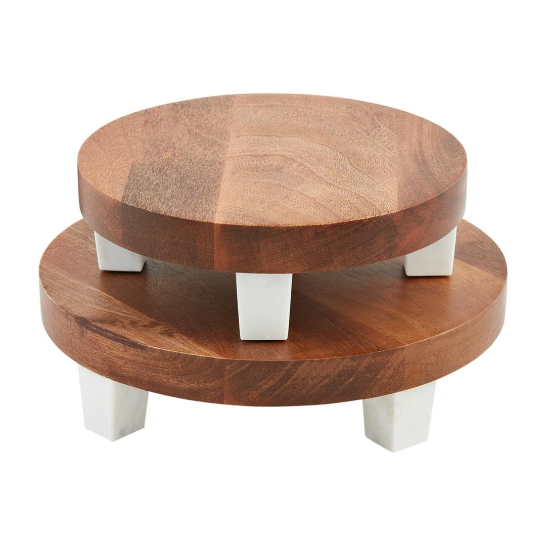 Two-tiered wooden cake stand with white legs on a white background