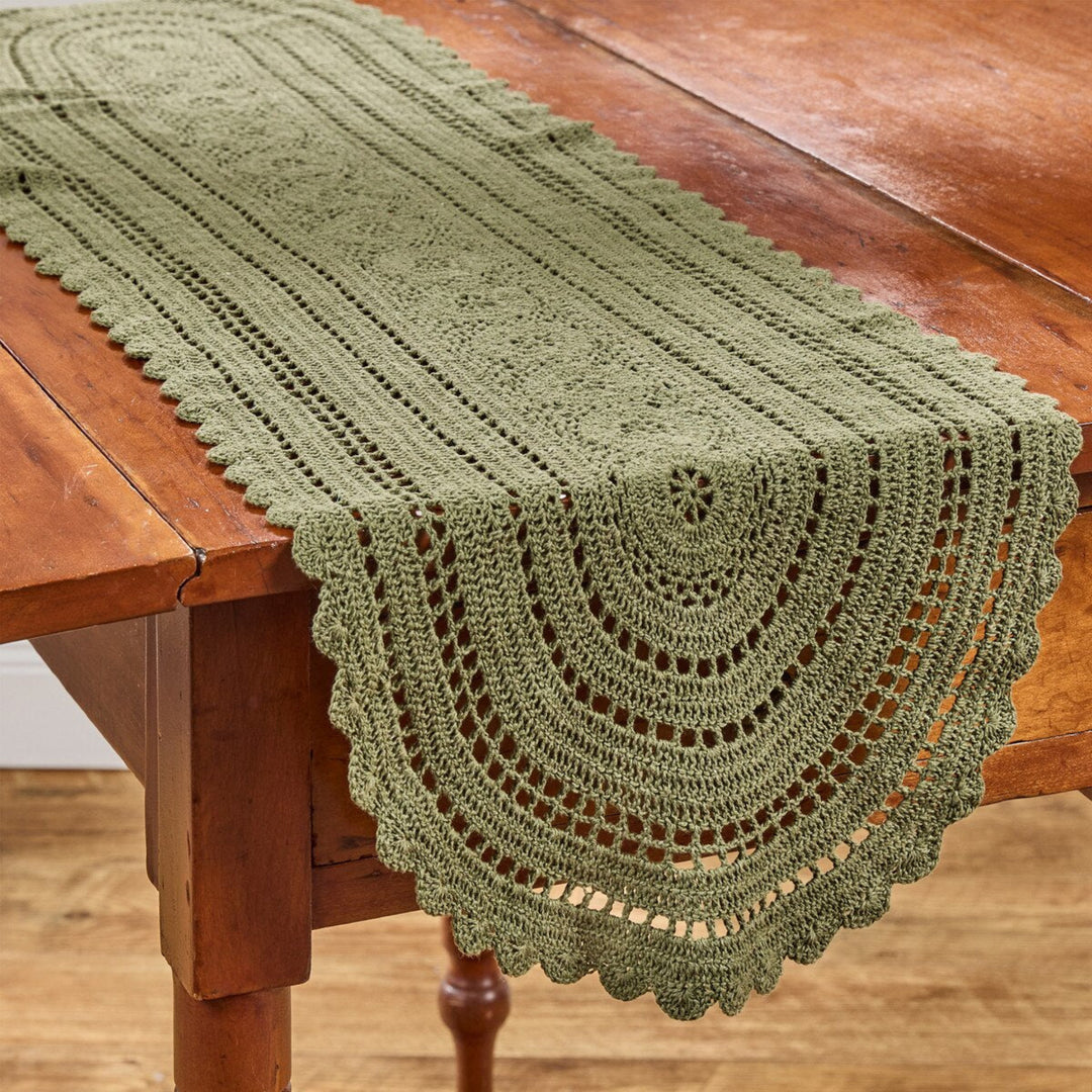 Green crocheted table runner on a wooden table