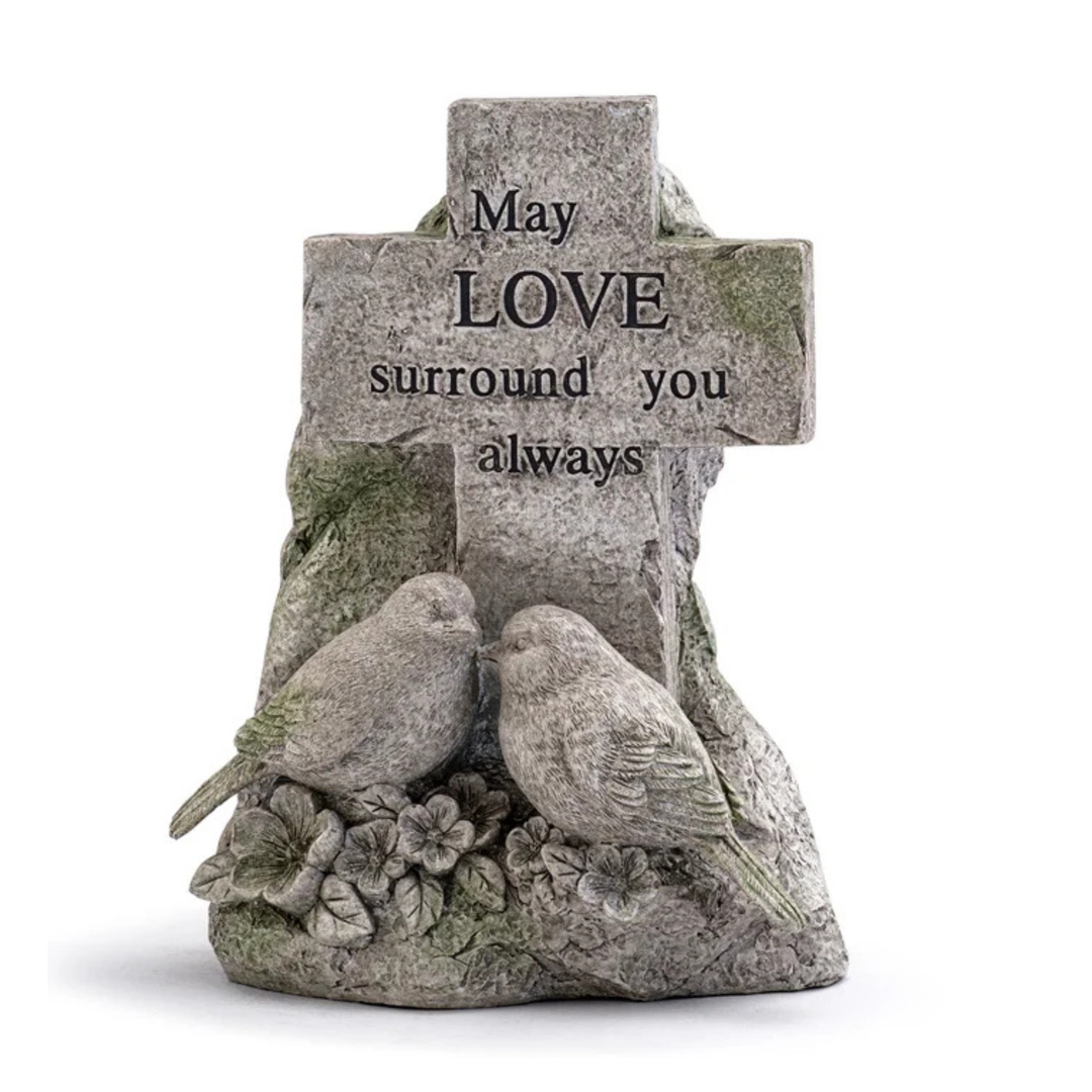 Stone cross with two birds and engraved text on a white background