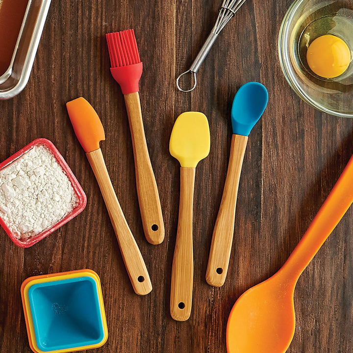 Colorful silicone spatulas and utensils on a wooden surface