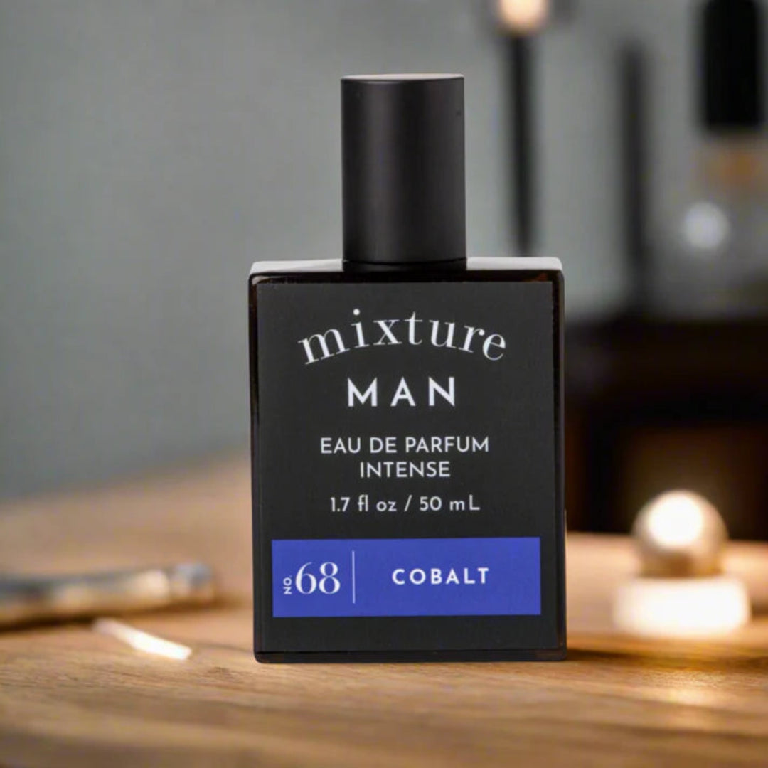 Perfume bottle labeled 'mixture MAN' on a wooden surface with a blurred background
