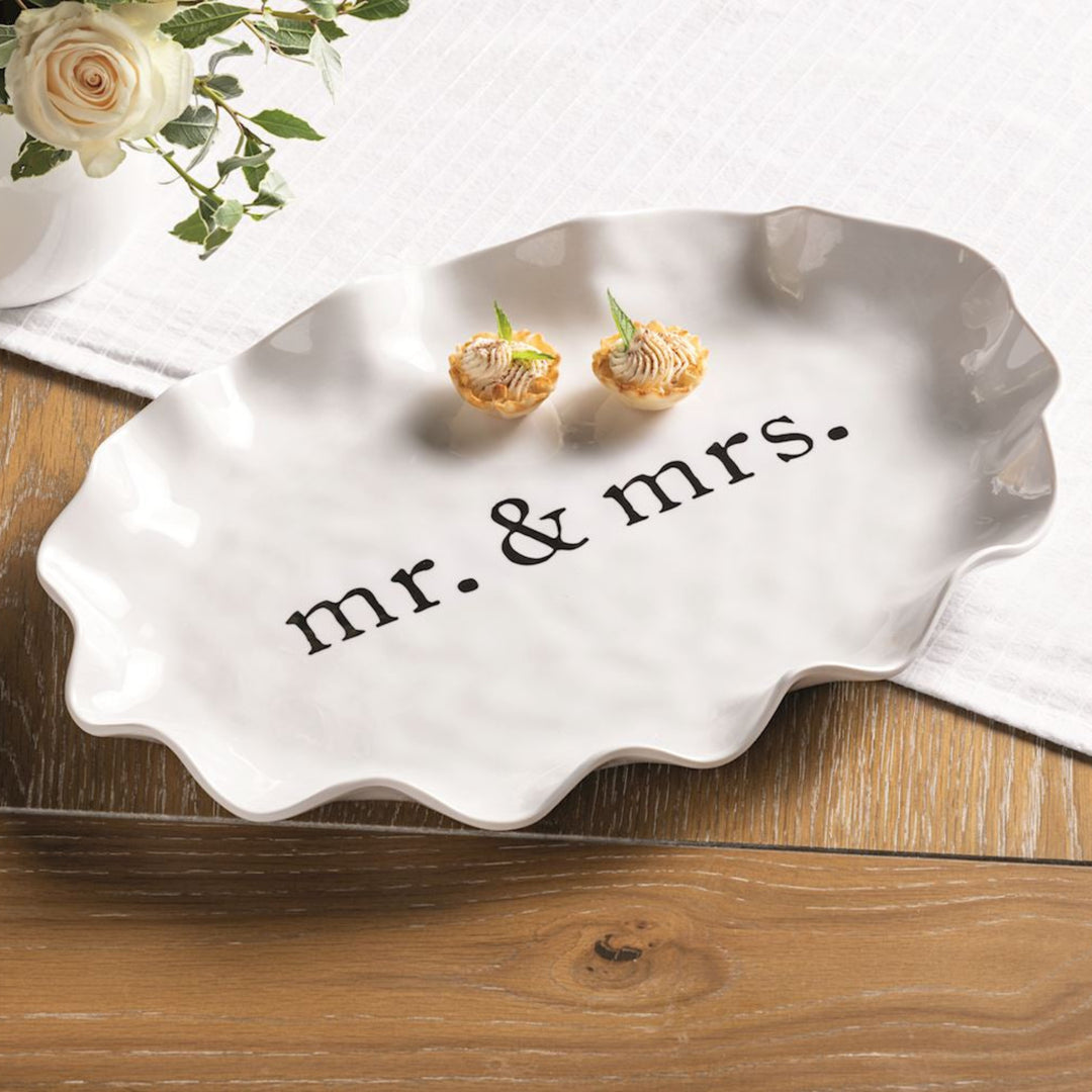 Silver 'mr. & mrs.' dish with earrings on a wooden surface