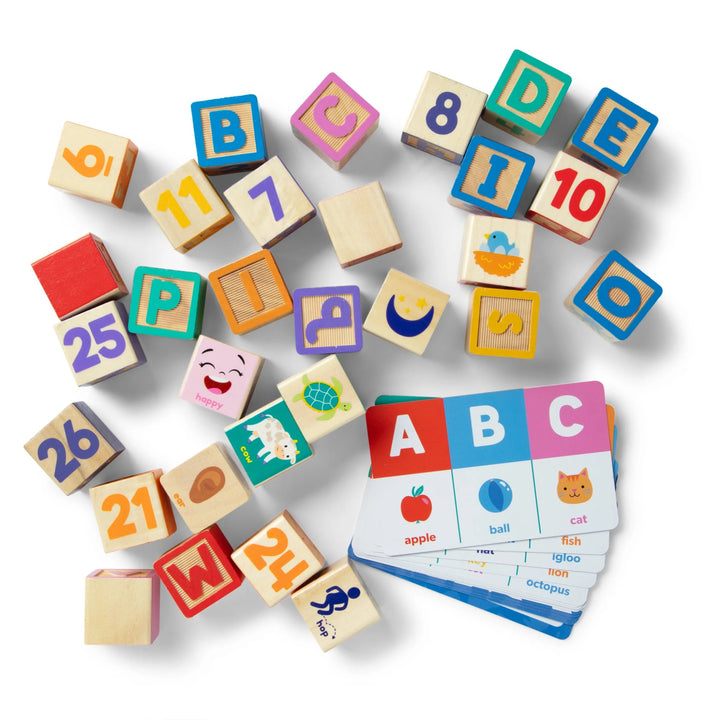 Colorful wooden blocks with letters and numbers, and a set of flashcards on a white background