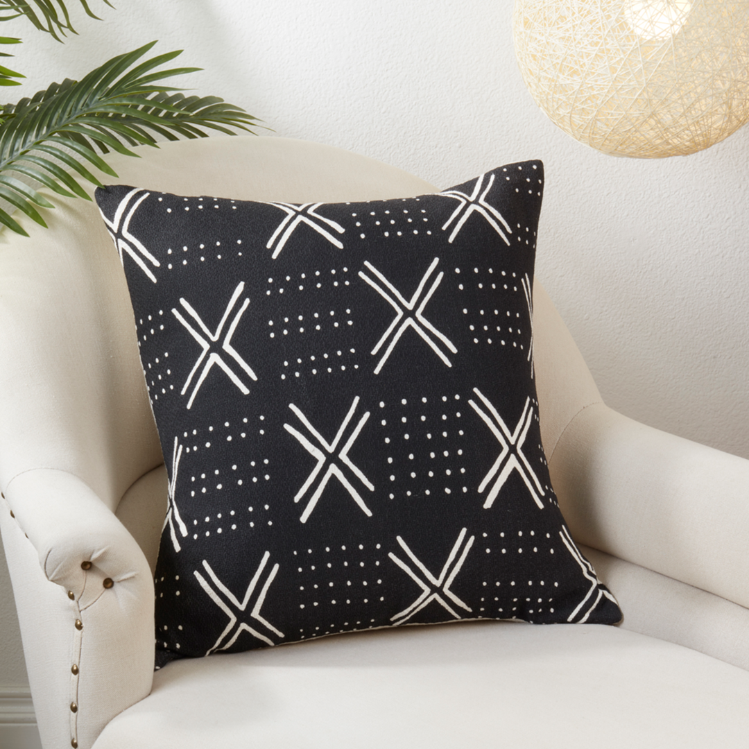 Black pillow with white geometric pattern on a white armchair