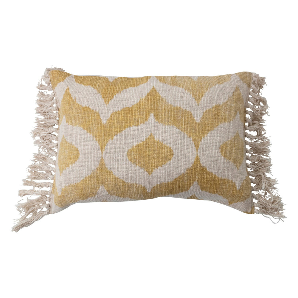 Yellow and white patterned pillow with fringes on a white background
