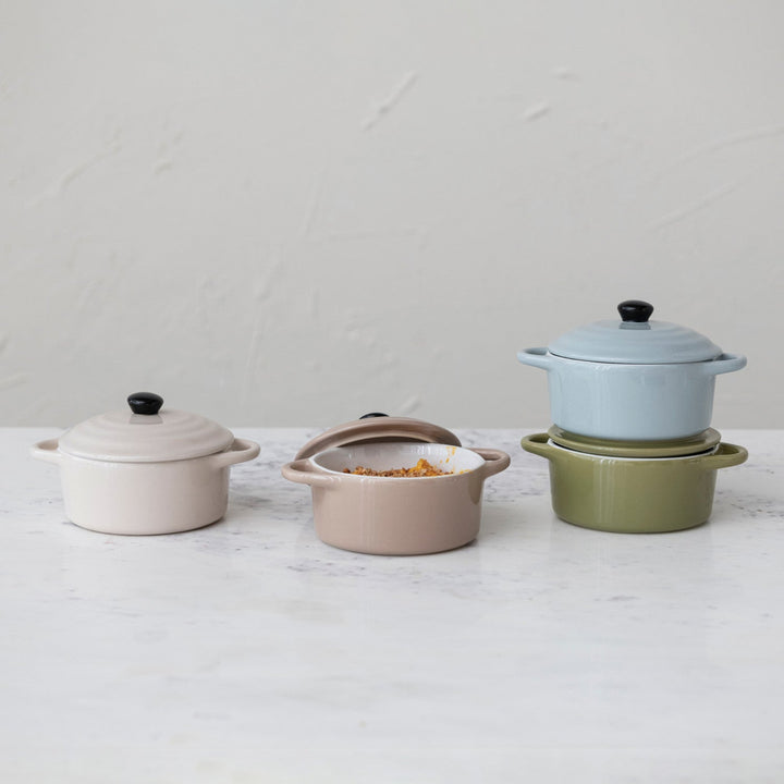 Set of colorful ceramic cookware on a white surface with a light gray background
