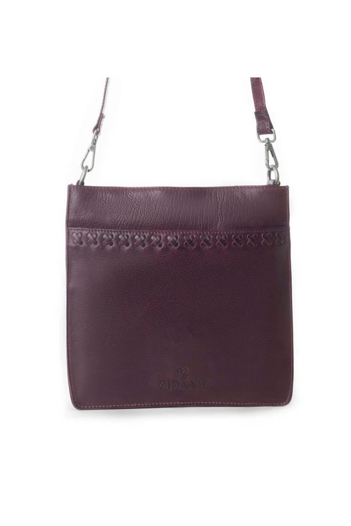 Purple leather handbag with decorative trim on a white background