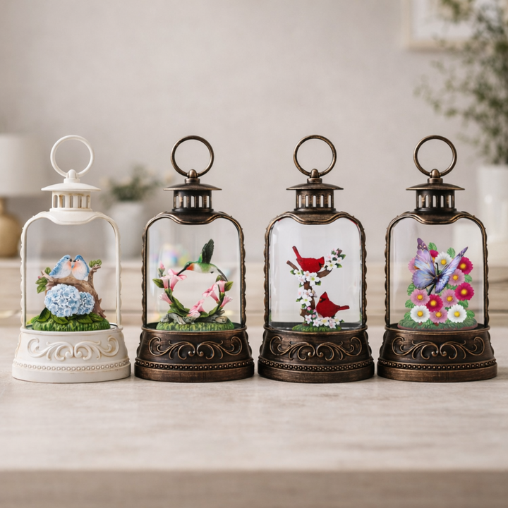 Four decorative lanterns with small scenes inside on a wooden surface.