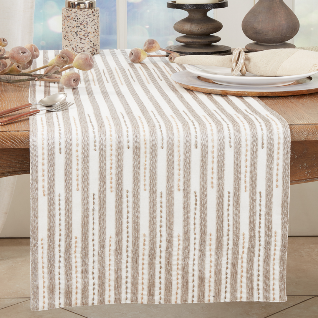 Table setting with a striped table runner on a wooden table.