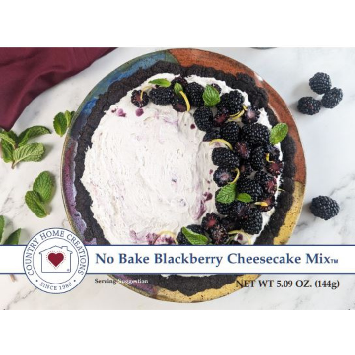 A round ceramic plate filled with a no-bake blackberry cheesecake mix, topped with fresh blackberries and mint leaves, on a white marble surface with scattered blackberries and mint leaves.