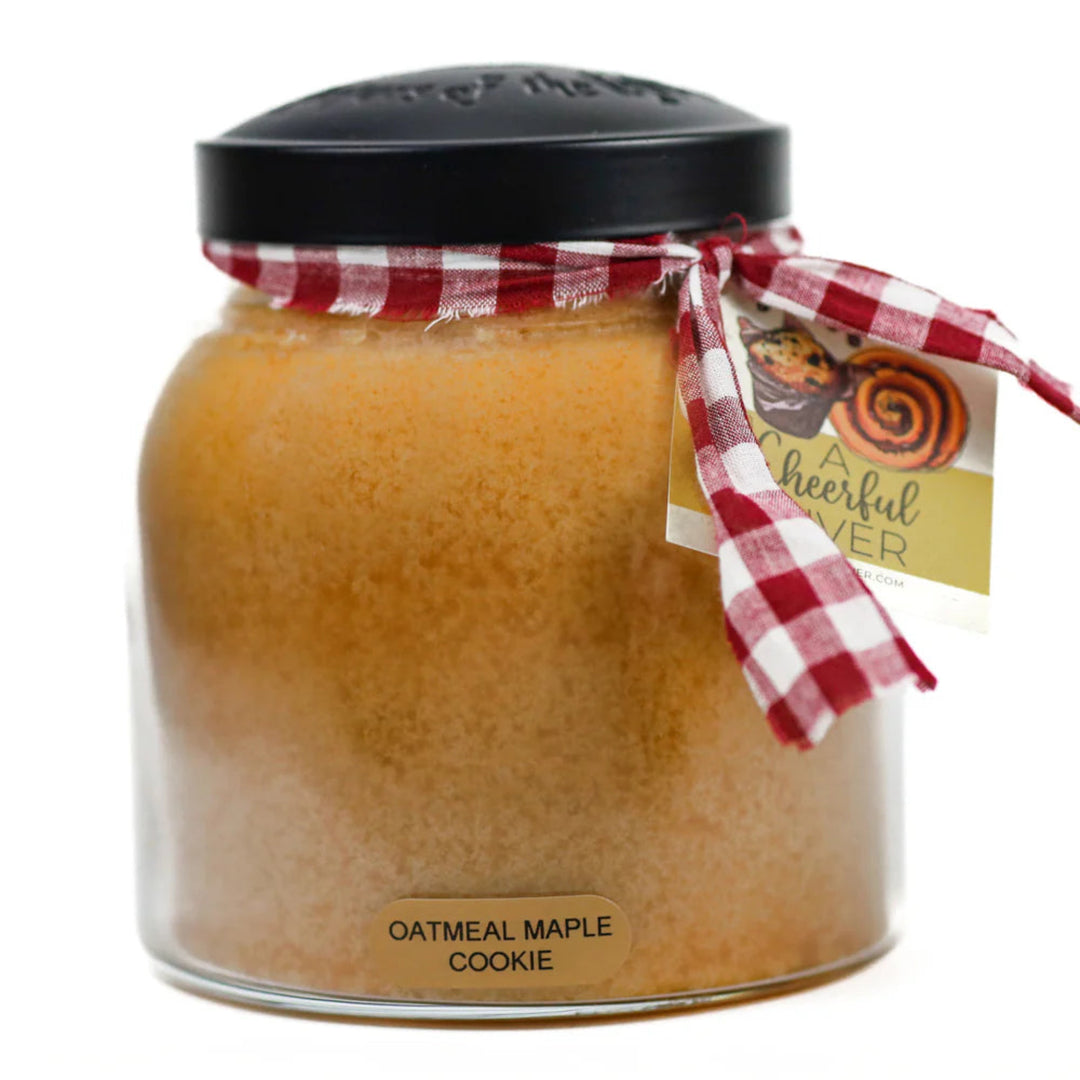Jar of oatmeal maple cookie-scented candle with a checkered ribbon and tag on a white background