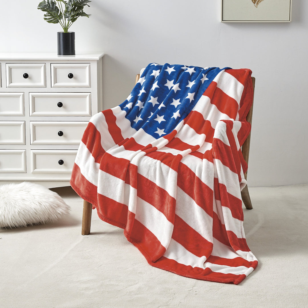 American flag blanket draped over a chair in a room with a white dresser and deer head mount on the wall.