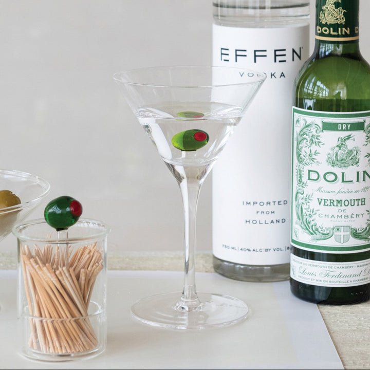 Bottles of Effen Vodka and Dolin Vermouth with a martini glass on a light surface.