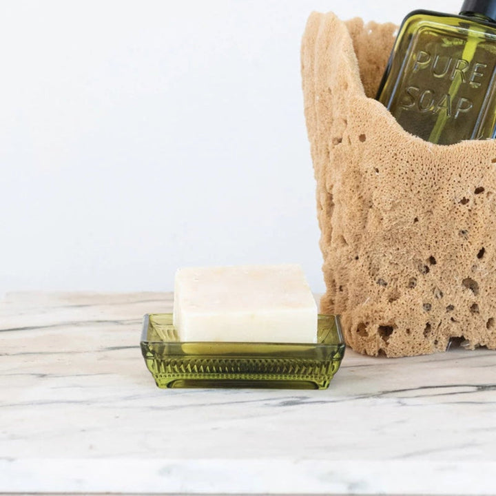 Sponge holder with a bottle and bar of soap on a wooden surface