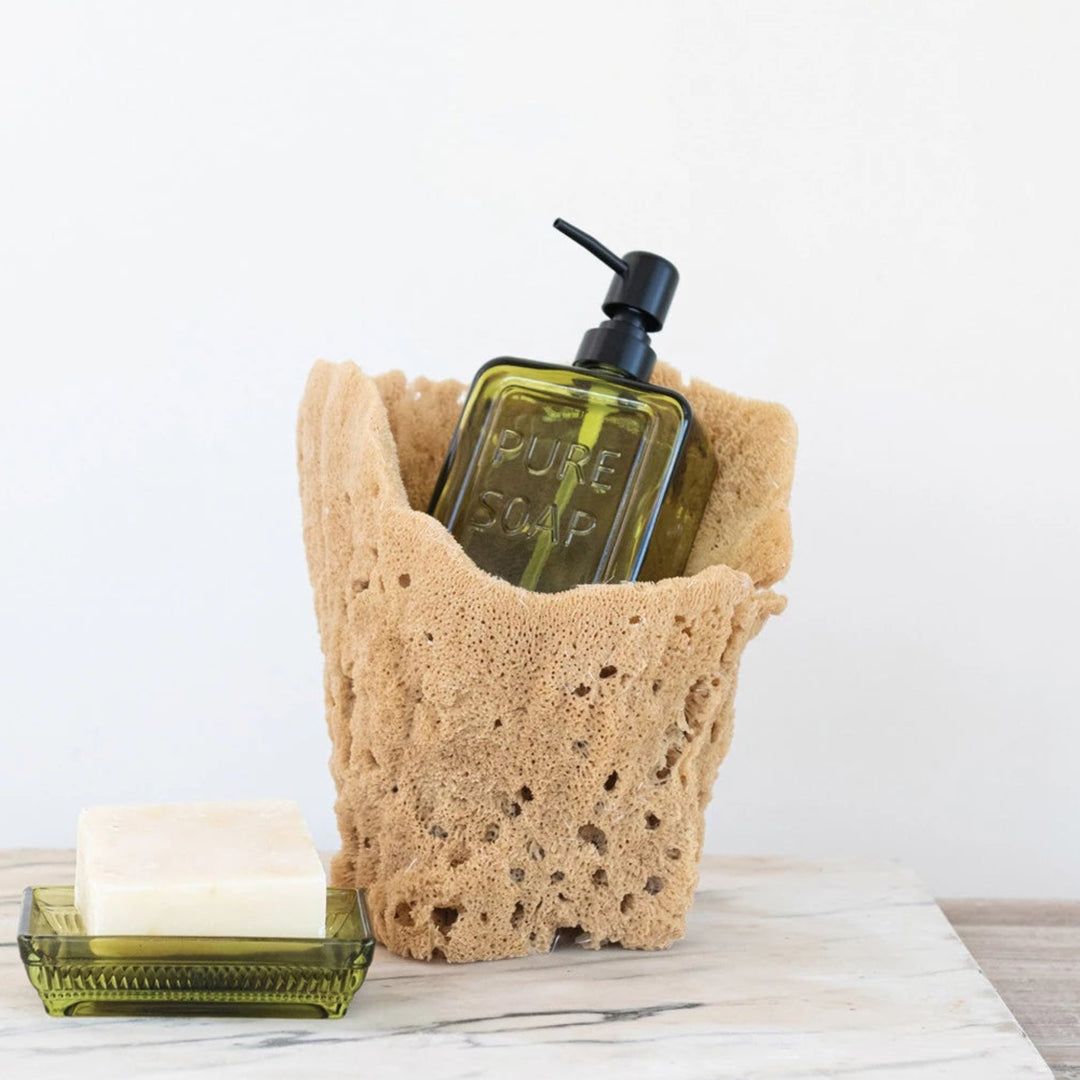 Sponge holder with a bottle and bar of soap on a wooden surface