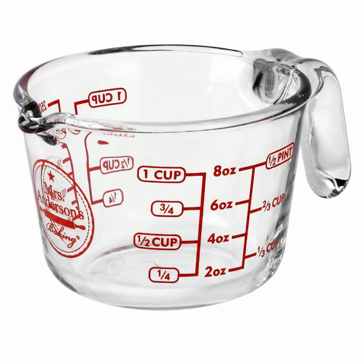 Clear measuring cup with red measurements on a white background