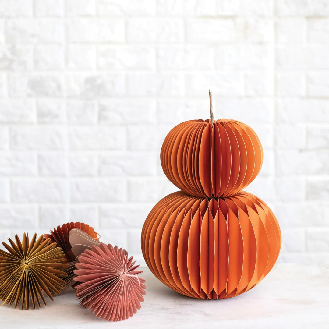 Decorative paper pumpkins on a textured white background