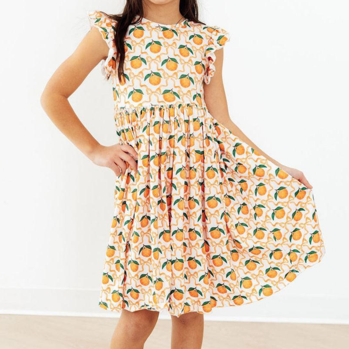 Dress with orange and green pattern on a plain background