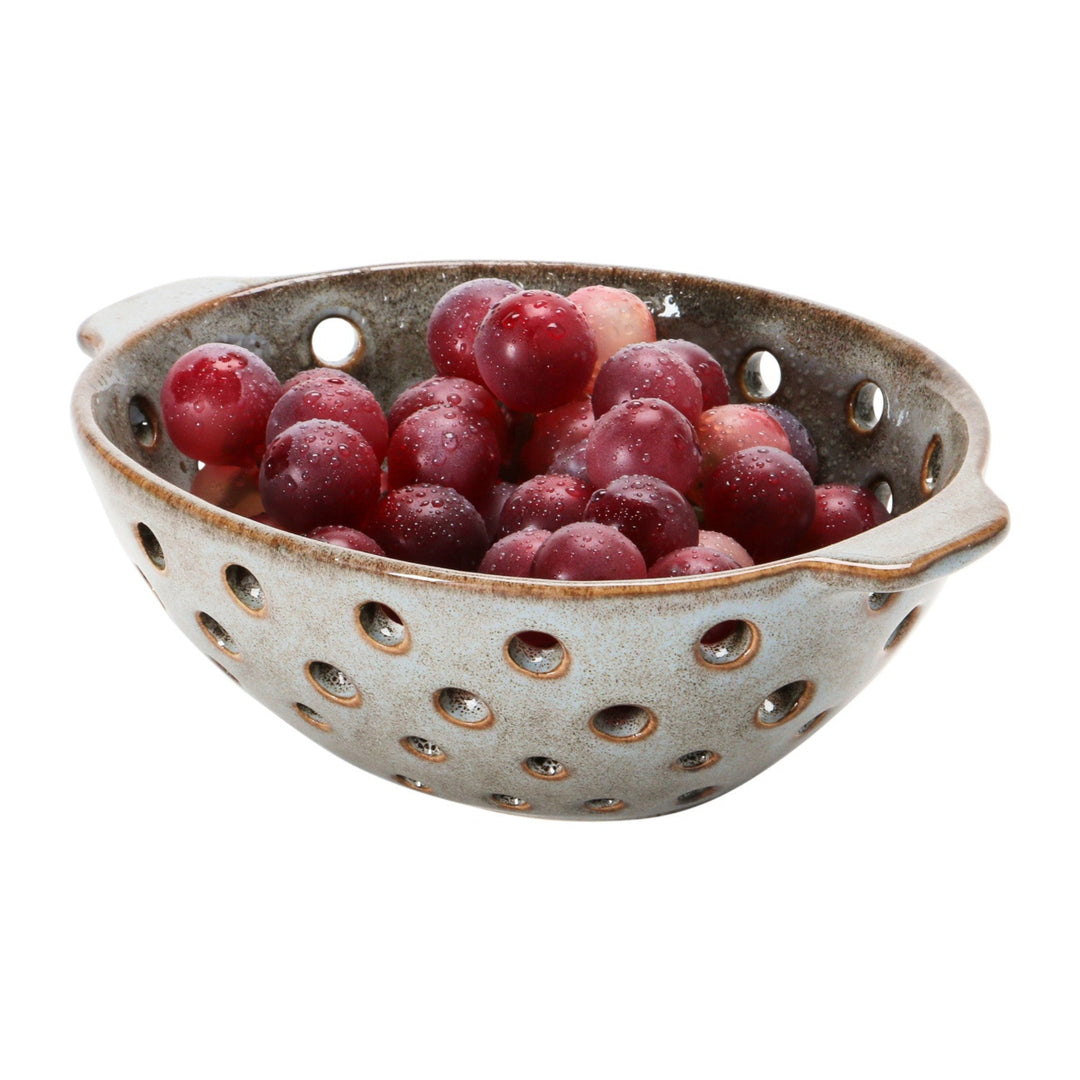 Ceramic colander with grapes on a white background