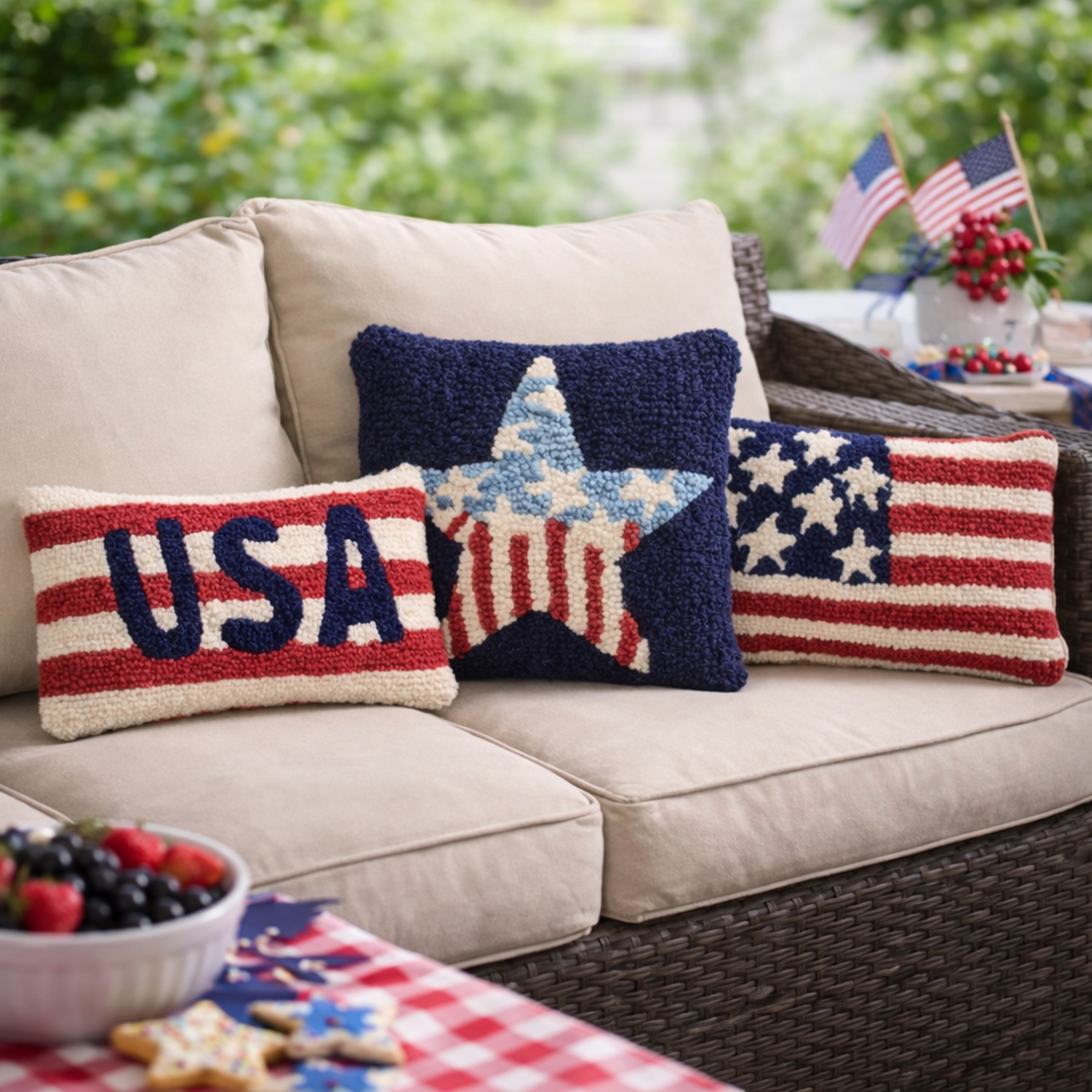 Decorative pillows with American flag design on a beige sofa outdoors.