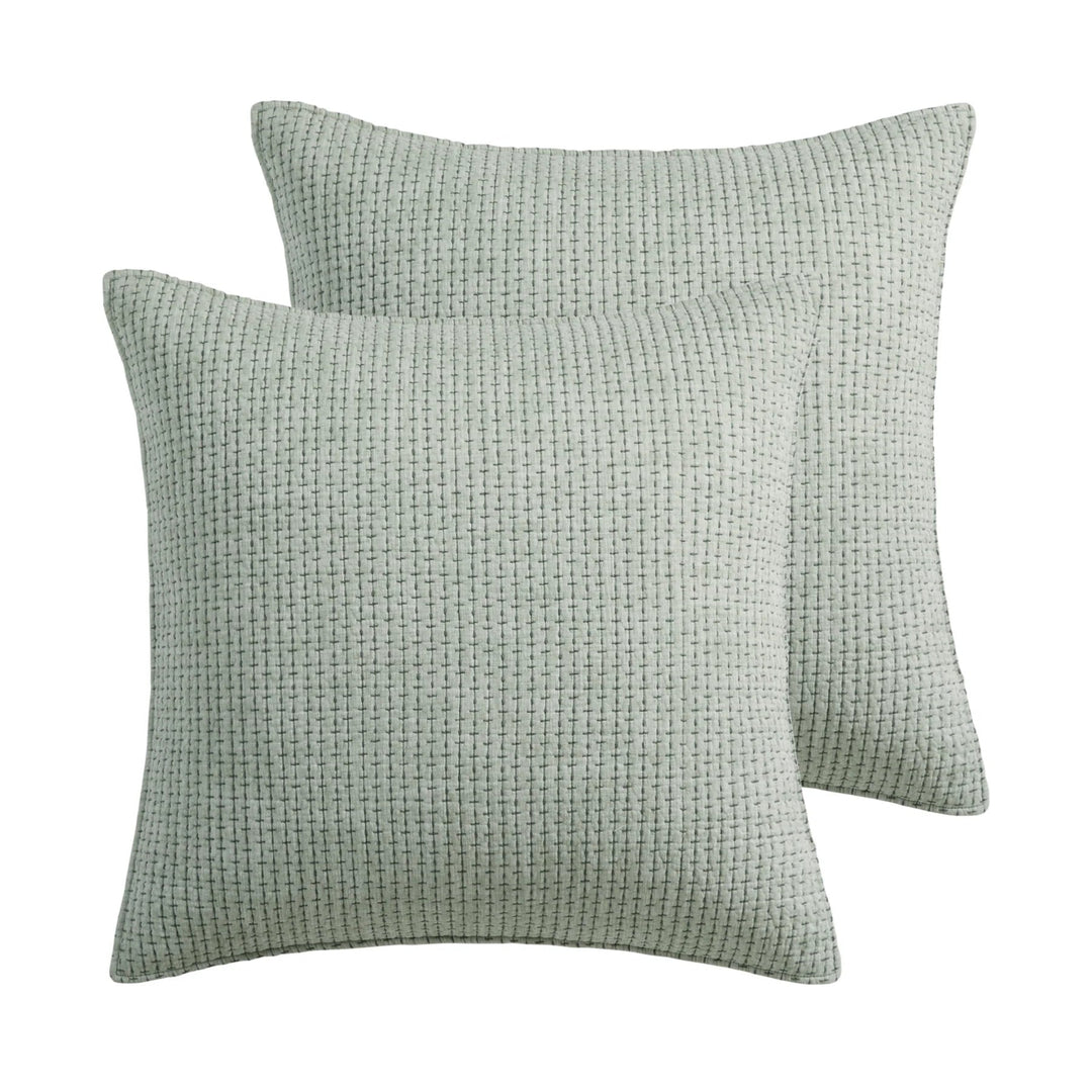 Two green textured pillows on a white background
