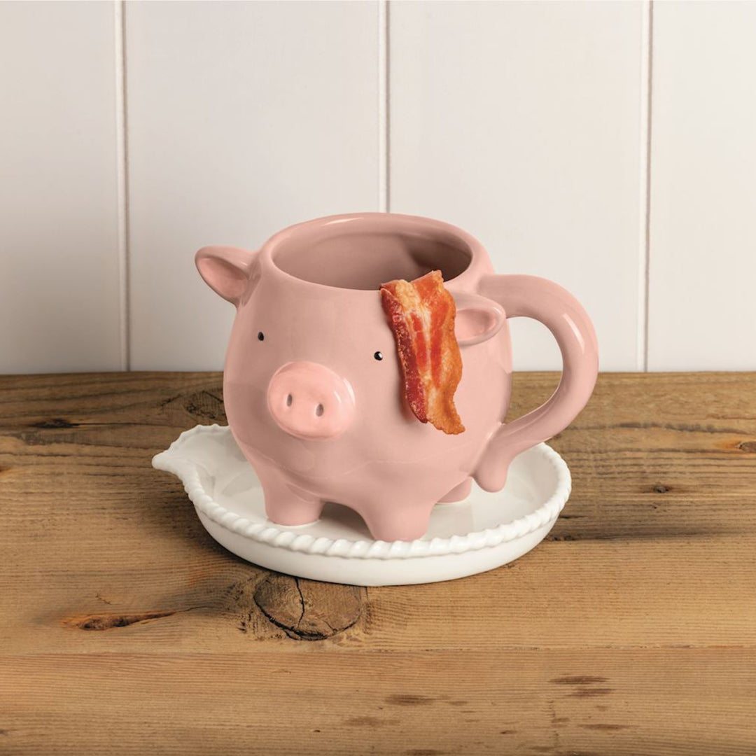Pink pig-shaped mug with a slice of bacon on a wooden surface