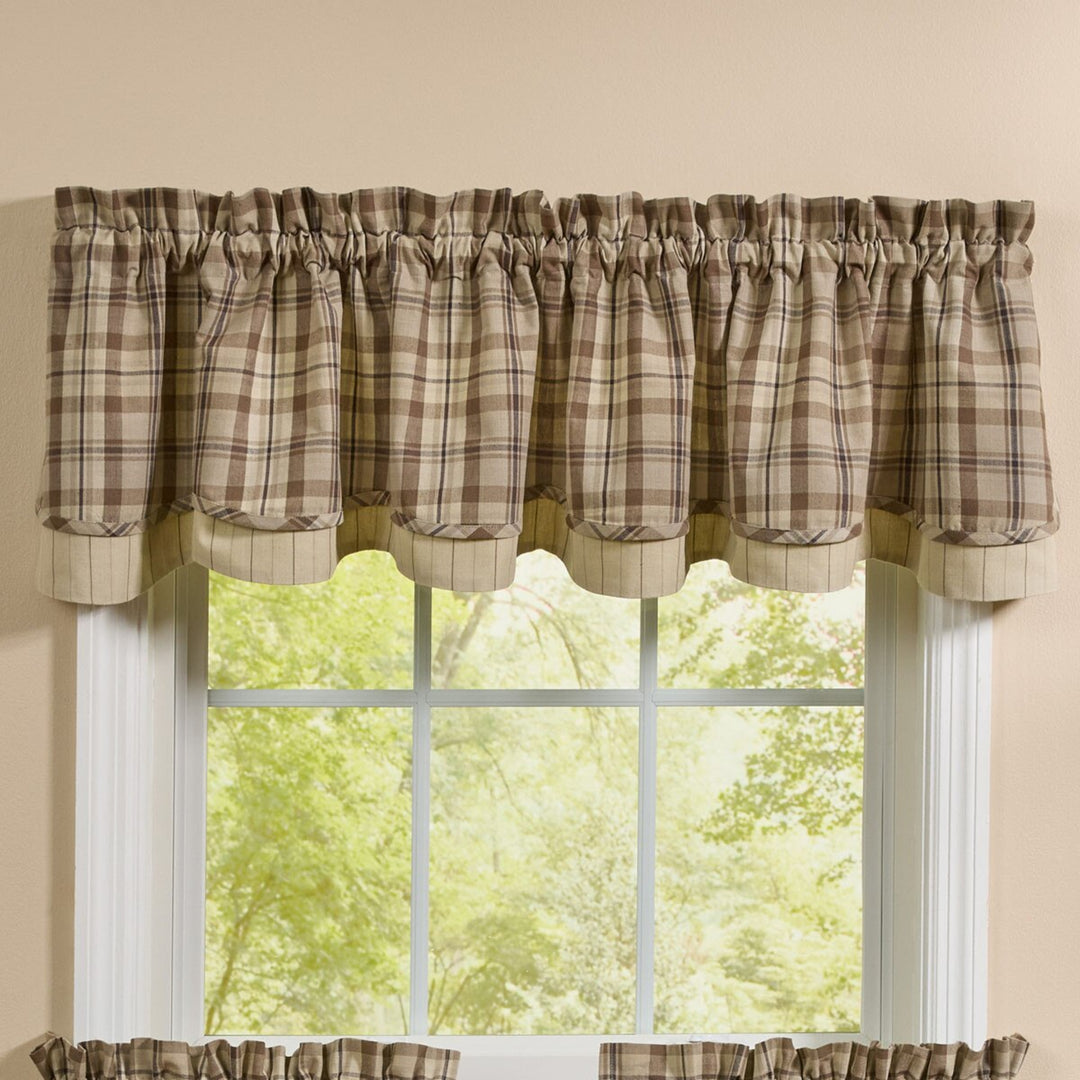 Plaid valance curtain on a window with a beige wall background