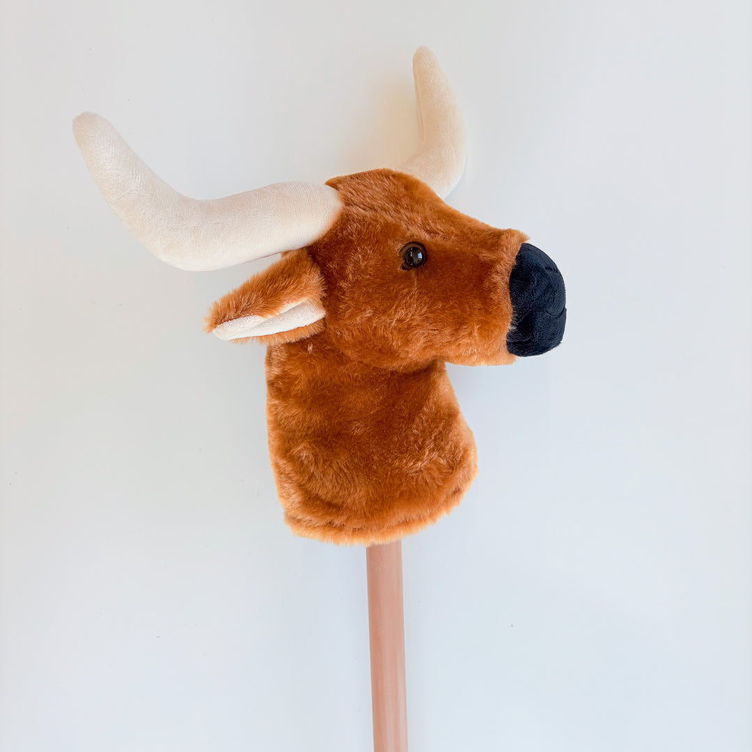 Plush bull head on a stick against a white background