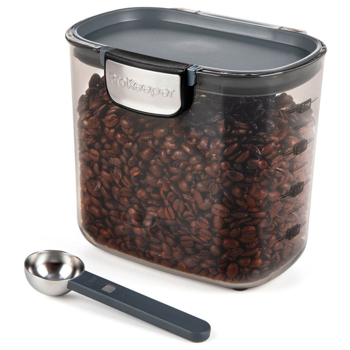Container of coffee beans with a measuring scoop on a white background