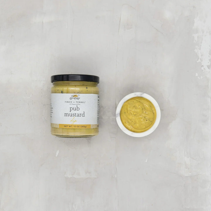 Jar of pub mustard with a small bowl of mustard on a light gray background