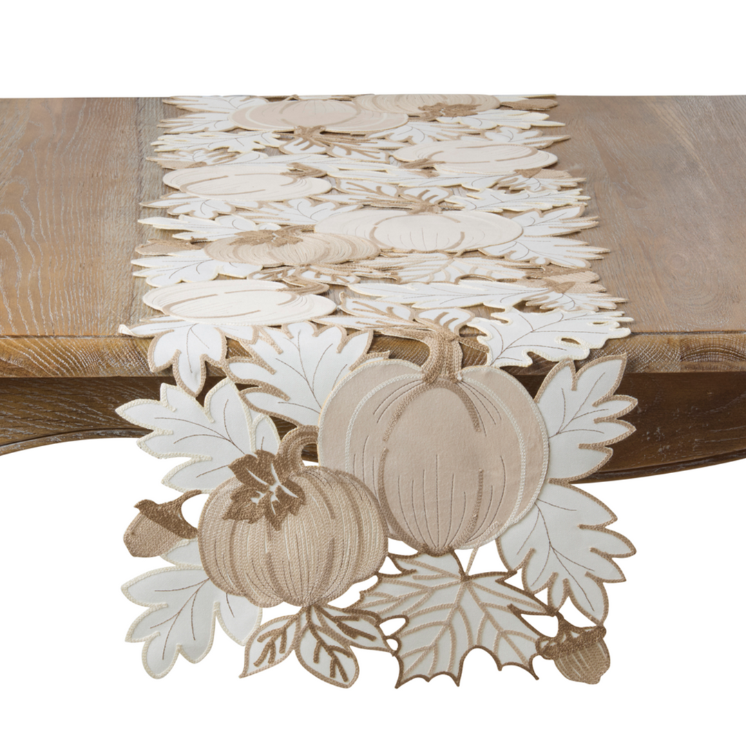 Decorative table runner with pumpkins and leaves on a wooden surface