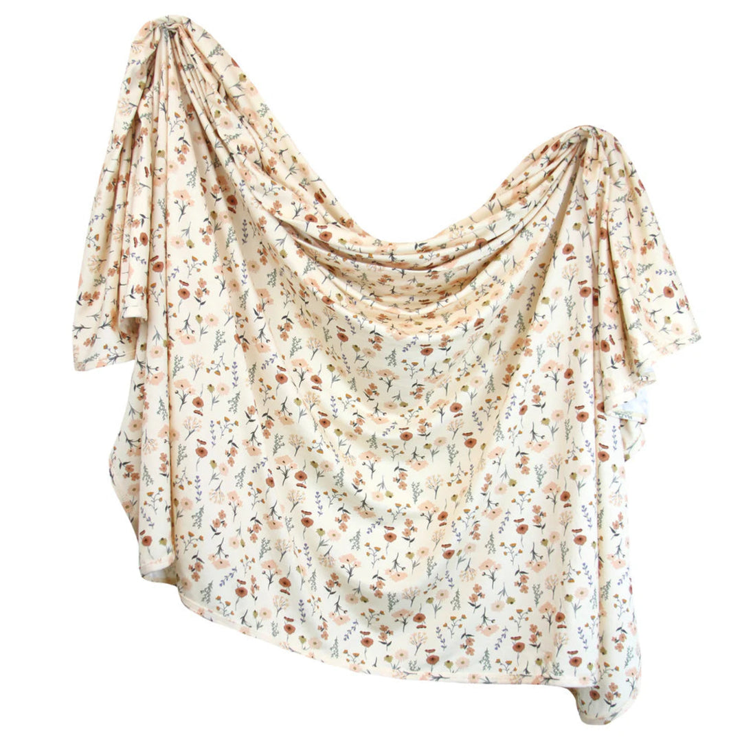 A draped, loose-fitting blouse or cover-up with a small-scale floral print in muted orange, brown, and green on a cream background, shown against a plain white studio background.