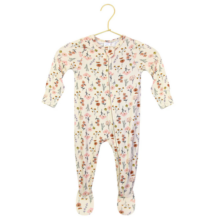 A baby footed sleeper with long sleeves and a front zipper, featuring an all-over floral print on a cream background. A circular inset in the bottom left corner provides a close-up of the floral pattern.