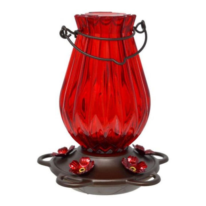 Red glass hummingbird feeder with black metal hook on a white background