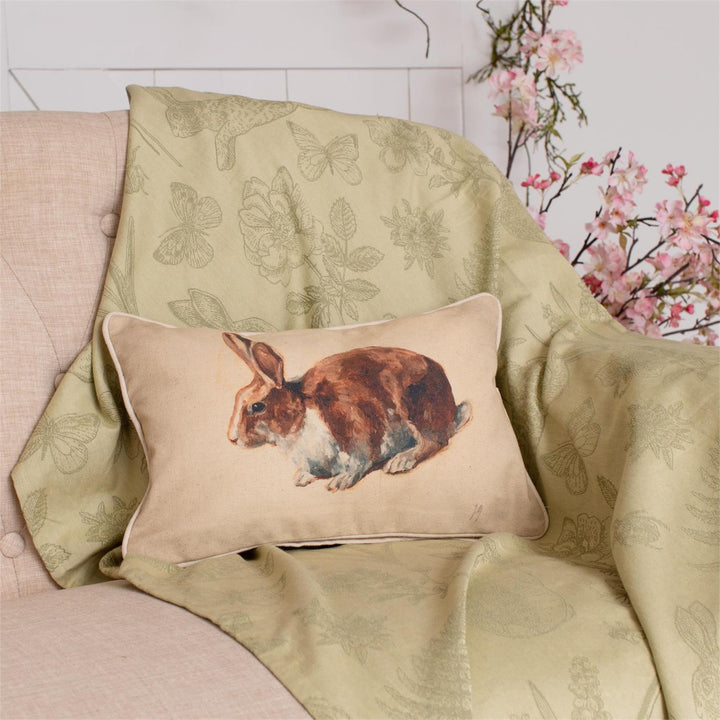 Decorative pillow with a rabbit design on a floral-patterned chair