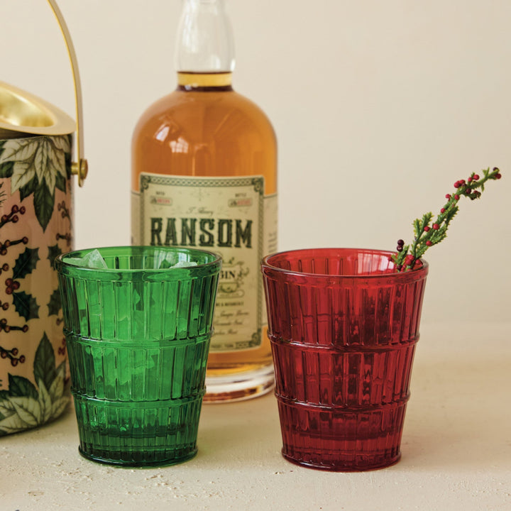 Two green and red tumblers with a bottle labeled 'Ransom' on a surface.