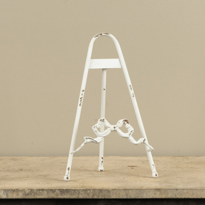 White metal ladder on a wooden surface with a beige background