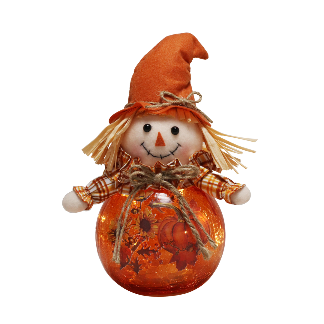 An autumn-themed decorative scarecrow doll with a tall orange hat, straw hair, a plaid orange-and-white shirt, and a round orange glass body decorated with a pumpkin and autumn leaf pattern.