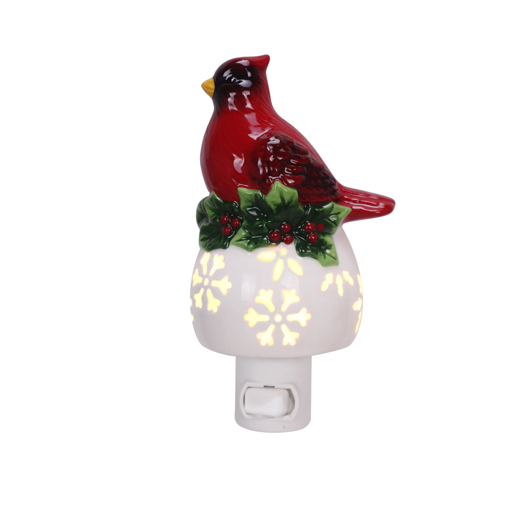 Three Christmas night lights on a white background: a snowman with a lit snowflake pattern, a red cardinal perched on holly with a glowing white base, and part of a lit Christmas tree.