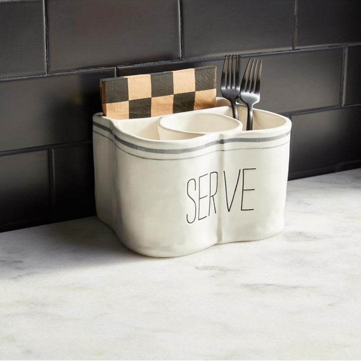 Kitchen utensil holder with cutlery against a tiled wall.